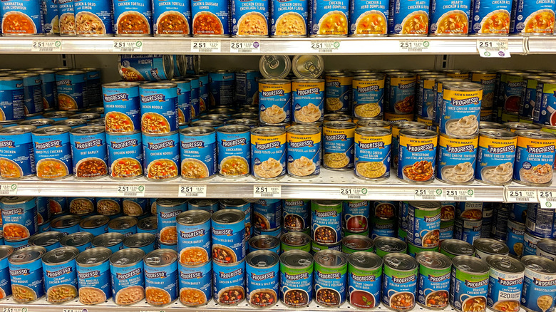Multiple cans of Progresso soup lined up on shelves.