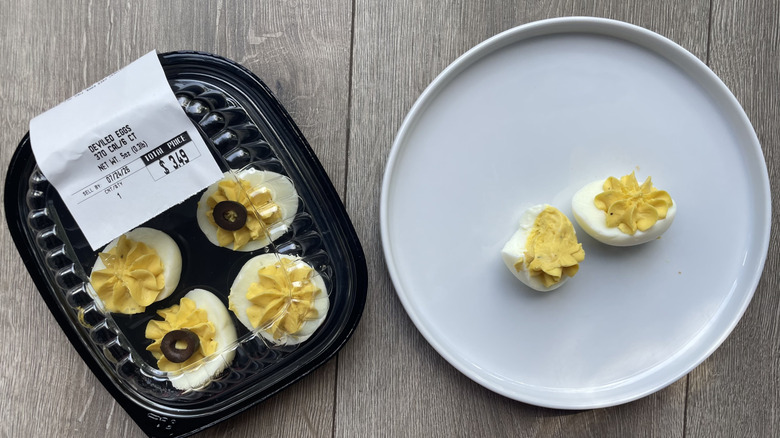 A package of deviled eggs from Publix and two on a white plate