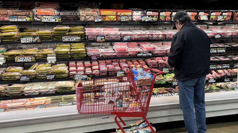 man shopping at aa Trader Joe's packaged meat section