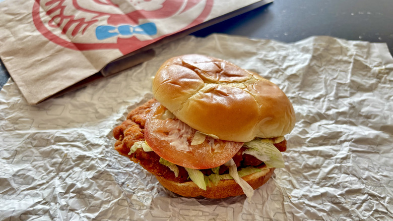 Wendy's chicken sandwich over a paper Wendy's logo