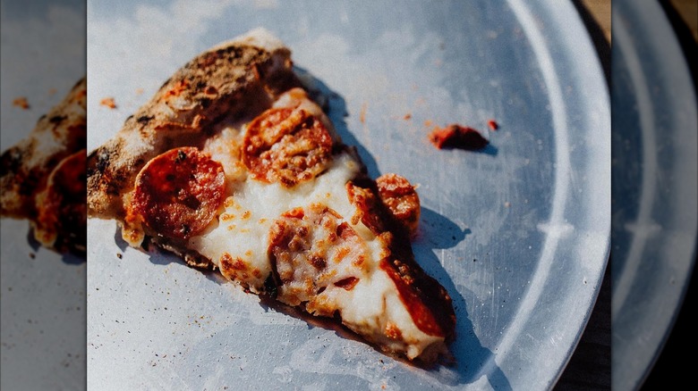 Single piece of pepperoni pizza on a silver tray