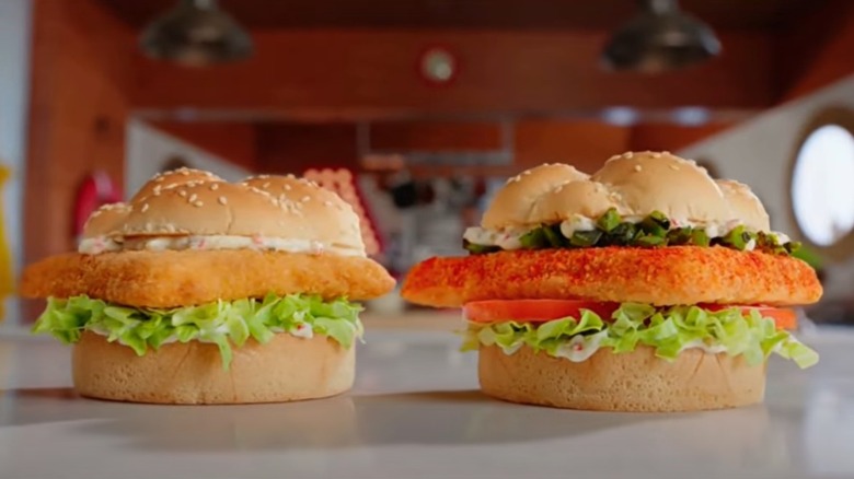 Commercial screenshot of Arby's regular and spicy fish sandwiches on a table on a boat