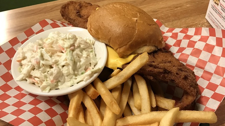 Fish sandwich with fries and coleslaw on a diner table