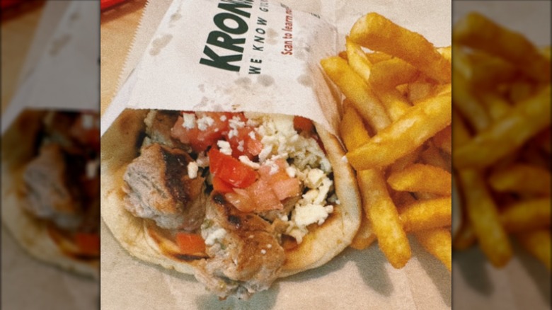 Close-up of a pork gyro with fries