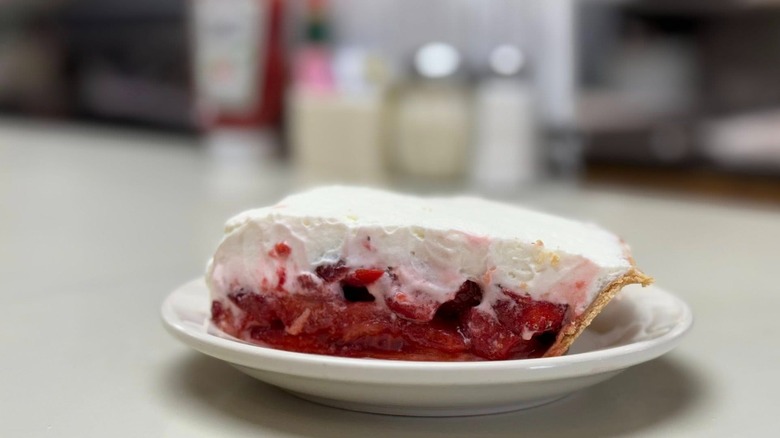 Slice of strawberry pie on a plate on a diner counter