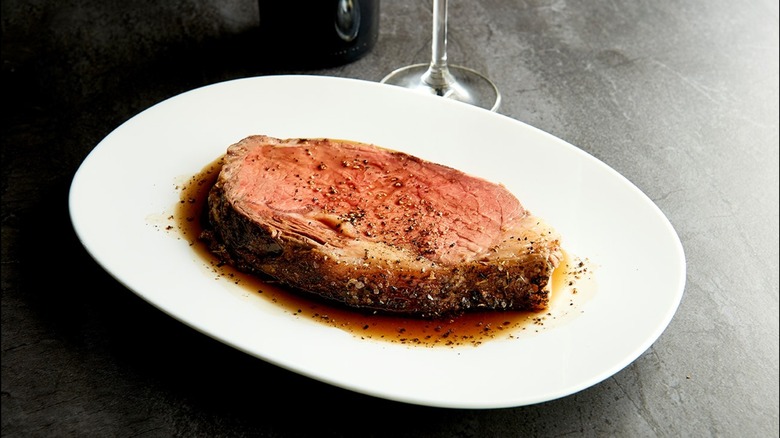 Prime rib on plate with wine glass