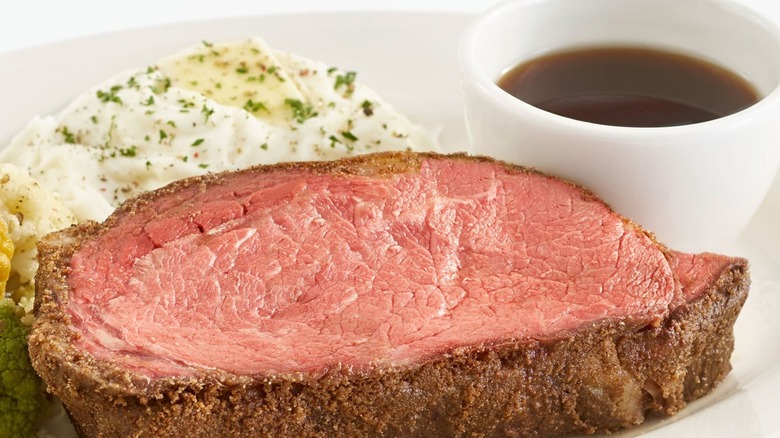 Slice of prime rib with mashed potatoes and au jus