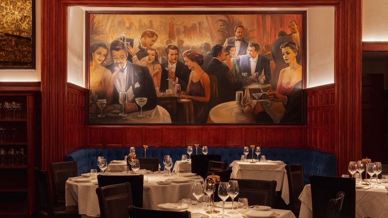 Tables at Delmonico's in front of a mural and blue booth