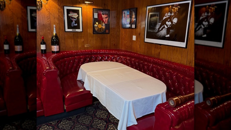 Elvis' red leather booth at the Golden Steer with gold records on the wall