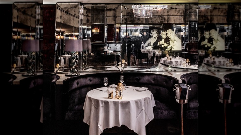 Booth with a table in front of a mirrored wall at Savoy Grill
