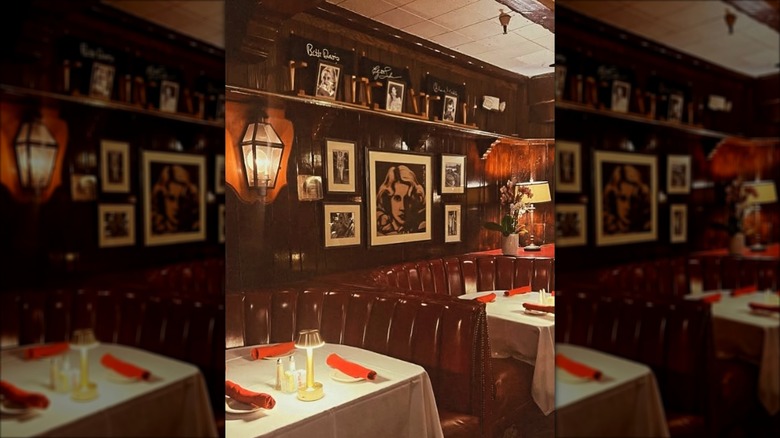 Red leather booths with tables in front of a wall of photos at Smoke House