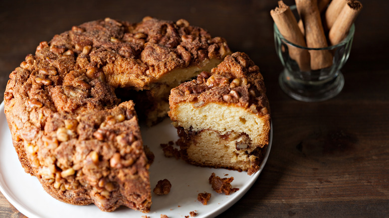 closeup of sliced coffee cake with cinnamon sticks in background