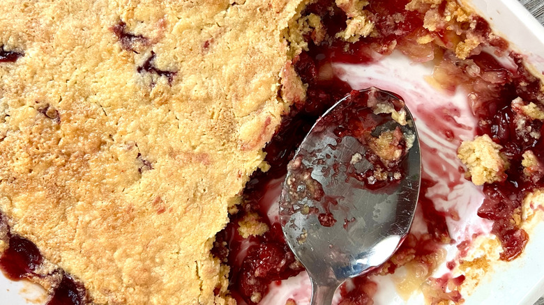 old fashioned dump cake in a baking dish with serving spoon