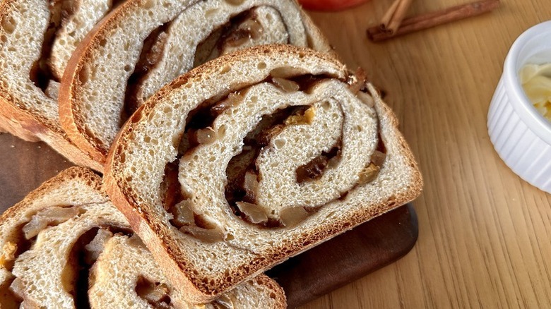 Slices of cinnamon-apple swirl bread on a wooden board