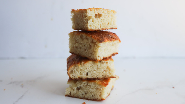 Stack of four focaccia bread slices on a white marble countertop