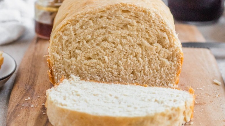 Sliced loaf of sandwich bread on a wooden board