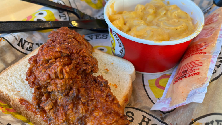 Spicy chicken tender on slice of bread and cup of mac and cheese from Dave's Hot Chicken
