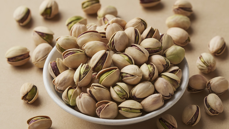 Pistachios scattered over a pink background