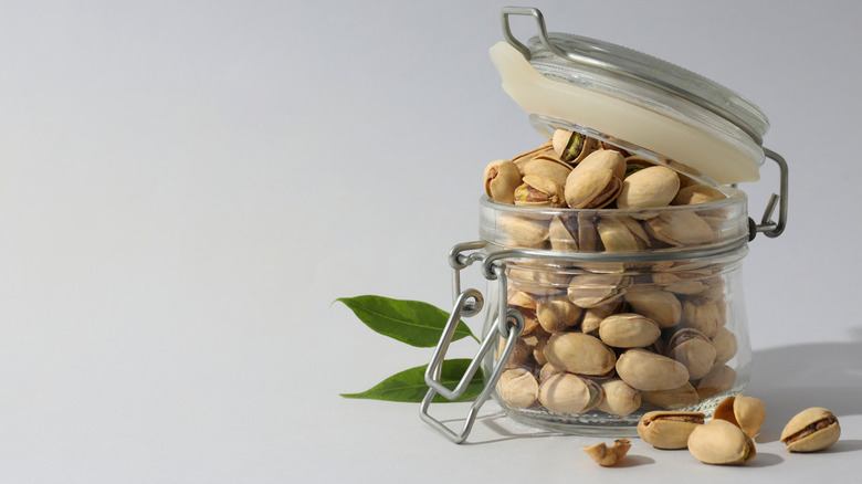 Pistachios in an overflowing open glass jar