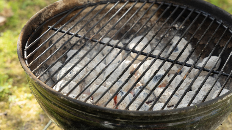 A Webber grill with ashy hot coals.