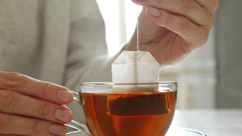 Woman taking tea bag out of cup