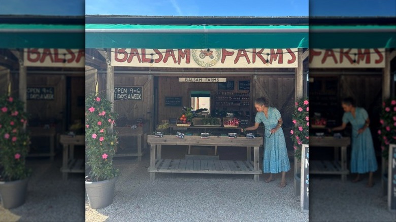 A woman tends to the farm stand at Balsam Farms