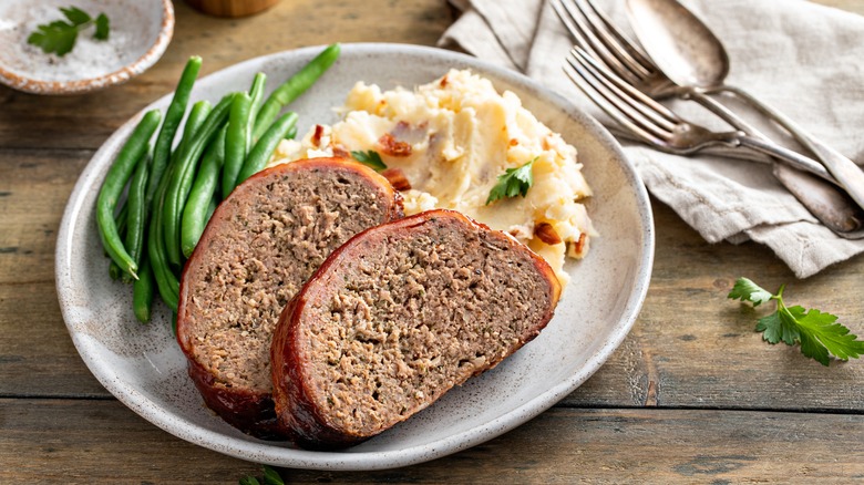 slices of meatloaf with mashed potatoes and green beans