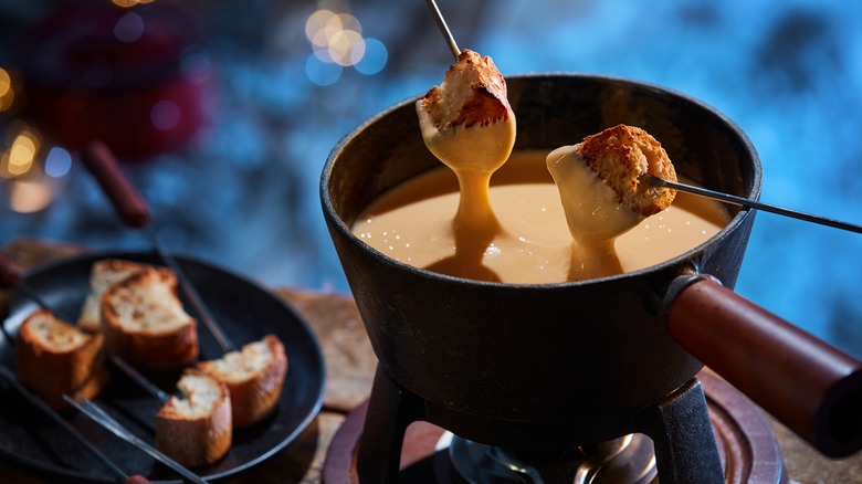 Skewered bread in a pot of fondue