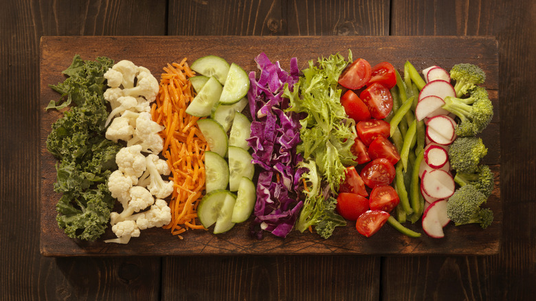 different raw vegetables lined on a cutting board