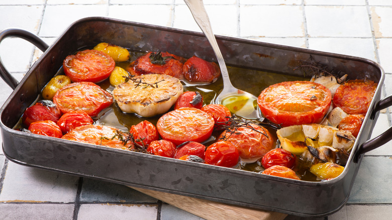 A sheet pan full of roasted tomatoes garlic and onion