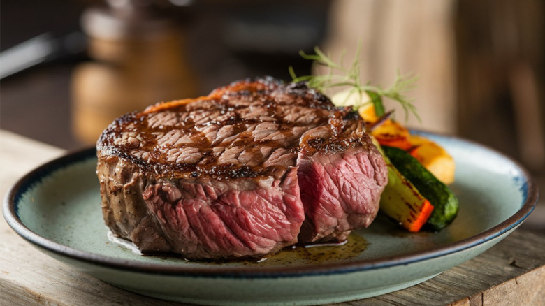 A premium cut of steak on a plate with vegetables