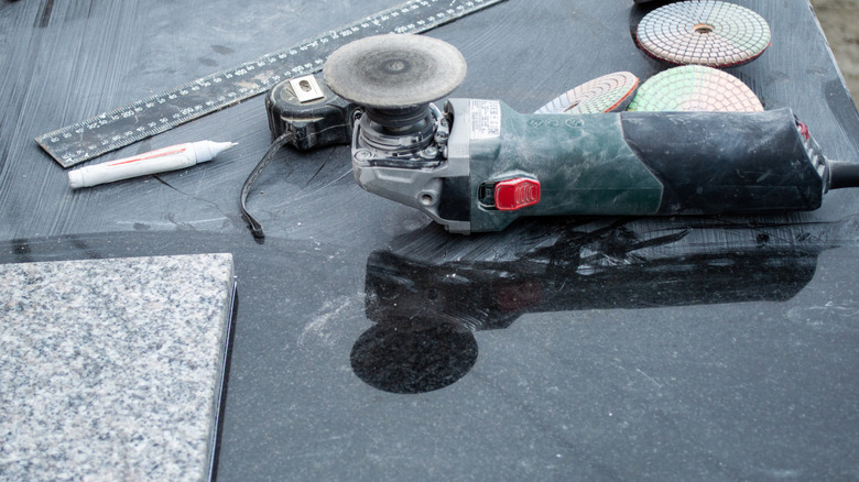 Stone polishing pads and tools resting on granite counter
