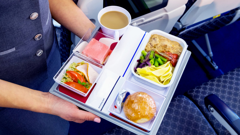 Flight attendant serving an in-flight meal