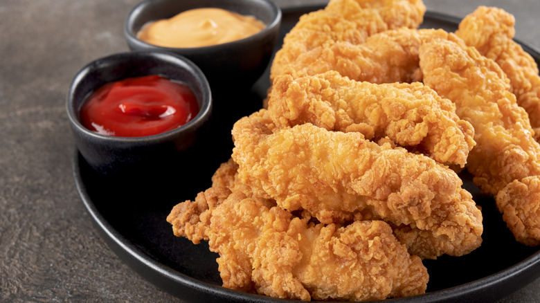 plate of chicken tenders with dipping sauces