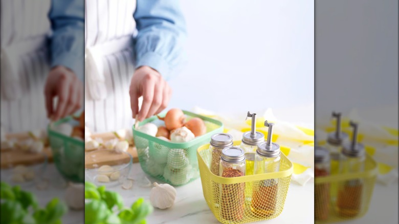 Person placing garlic into Ikea storage basket on counter