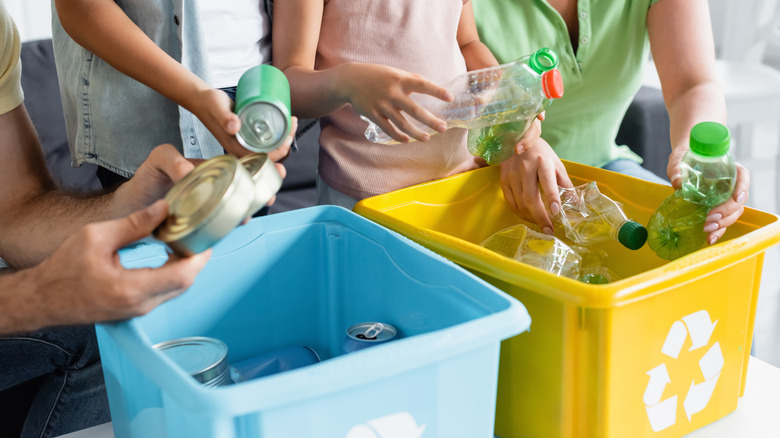 a family of four sorting recycling into appropriate bins