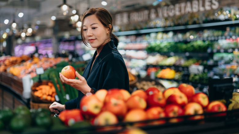 Woman shopping for apples at grocery store