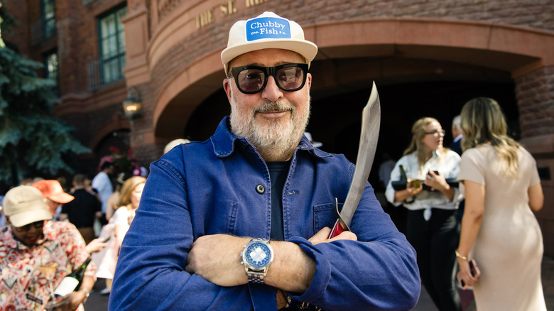Andrew Zimmern posing with a carving knife