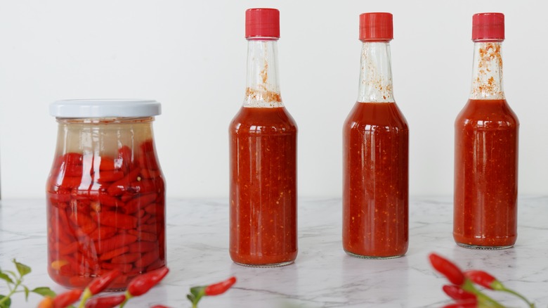 four jars of red hot sauce