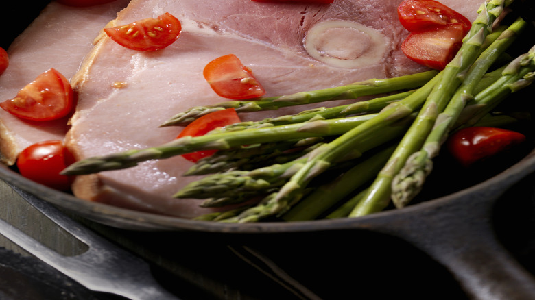 Close-up of ham steak, asparagus, and cherry tomatoes