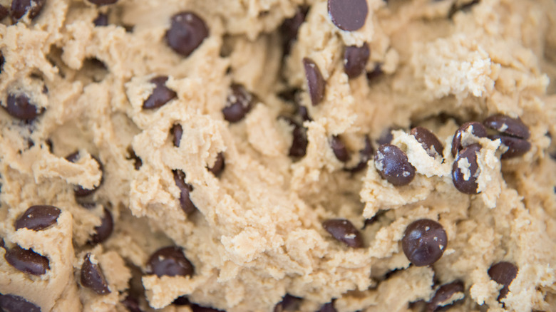 A close-up of raw chocolate chip cookie dough fills the frame.