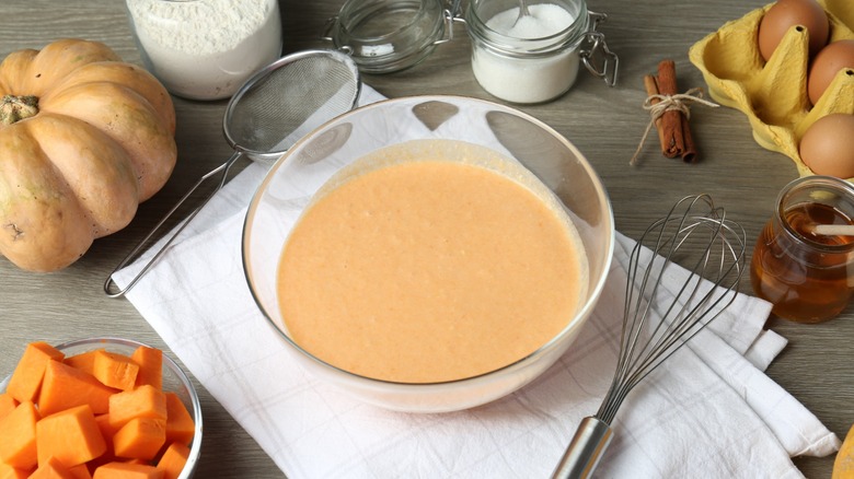 Different ingredients for pumpkin pancakes on wooden table.