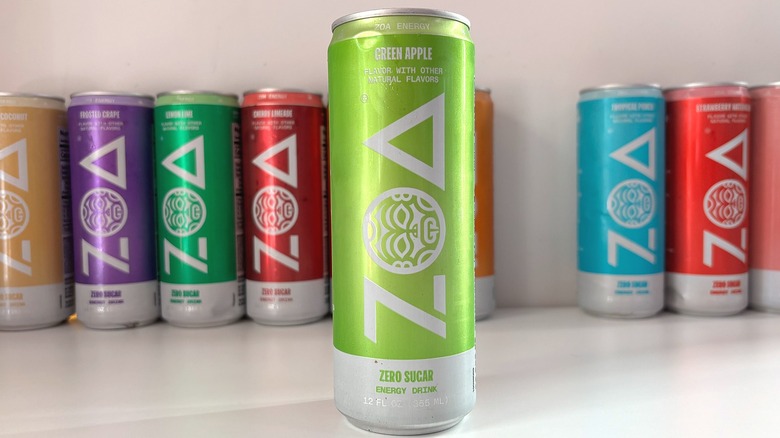 Can of Green Apple ZOA energy drink on white table, other cans behind